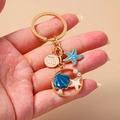 Portachiavi tema oceano con stella marina, ciondolo conchiglia blu e segno dello Scorpione - Scorpione Stella Marina Conchiglia / Blu