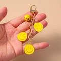 Portachiavi con faccina sorridente con ciondoli in smalto giallo e campanellino - Giallo