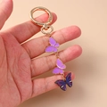 Portachiavi creativo con farfalle in smalto viola e chiusura a moschettone oro - Viola