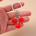 Porte-clés tortue en résine rouge avec trois petits pendentifs sur un anneau argenté - Rouge