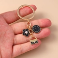 Llavero dorado con flor negra, reloj romano y colgante de bolso acolchado - Negro
