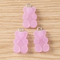 Three pink resin gummy bear pendants with silver rings on a light natural wood background - 20 Pieces Set / Purple