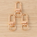 Three rose gold star-shaped lobster clasps on a wooden surface for DIY keychains - Keychain Hook (Rose Gold)