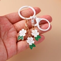 Porte-clés fleur de cerisier avec pétales en émail blanc et détails dorés sur chaîne dorée - Blanc