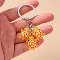 Vue de trois porte-clés tortue mignons en résine jaune avec des motifs colorés en main - Jaune
