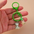 Détail d'un porte-clés ours vert avec un pendentif en résine pailletée et une petite bouteille - Ours Sucre Vert
