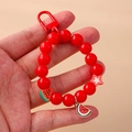 Porte-clés perlé avec pastèque et étoile rouge tenu à la main sur un fond beige minimaliste - Pastèque (Rouge)