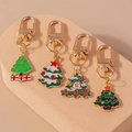 Detail of four colorful Christmas tree keychains with golden metal D-rings on a beige stand - Full Set Style