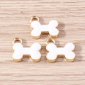 Detailed view of three white enamel bone-shaped charms with gold-plated edges on wood - 10 Pieces Pack / White