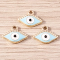 Tres colgantes de ojo de la suerte dorados con esmalte azul sobre madera clara - Azul claro