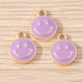 Three purple enamel smiley face charms with golden outlines on a light wood background - 10 Pieces Pack / Purple