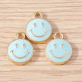 Close-up of three light blue enamel smiley face pendants with gold trim for DIY jewelry - 10 Pieces Pack / Light Blue