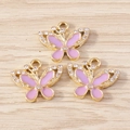 Dettaglio macro di tre ciondoli a farfalla in smalto rosa con cristalli su legno - Farfalla Viola (YD1695jinzi) / Confezione da 10 / Oro