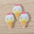 Close-up of cute 3D resin ice cream charms with bows and heart glasses for DIY crafts - White