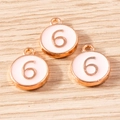 Three rose gold alloy charms with number 6 and white enamel on light wood background - 10 Pieces Pack / Pink Number 6 (YD1814fense6)