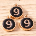 Macro shot of three gold-plated number 9 charms with black enamel finish for DIY jewelry - 10 Pieces Pack / Black Number 9 (YD1814heise9)