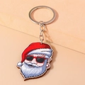 Dettaglio di un portachiavi di Babbo Natale cool con occhiali rossi su sfondo beige - Babbo Natale con Occhiali da Sole