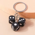 Creative keychain featuring three black resin dice pendants with silver metal ring - Black