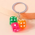 Fun acrylic resin dice keychain featuring vibrant green, pink, and orange translucent cubes - Orange Green Red