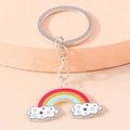 Simpatico portachiavi arcobaleno con nuvole e anello in argento su sfondo rosa delicato - Nuvola Stella Arcobaleno