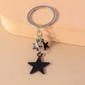 Llavero de estrella con anillo plateado y tres colgantes de estrellas negras mate en cadena - Estilo Estrella