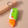 Detail view of colorful 3D gravity carrot knife keychain with retractable plastic blade - Green