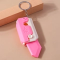 Close-up of pink and white plastic gravity knife keychain with crown logo detail - Pink