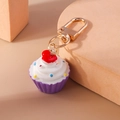Detailaufnahme von Cupcake-Schlüsselanhänger mit lila Basis und buntem Sahne-Topping - Lila