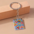 Dettaglio di un portachiavi in acrilico con farfalle colorate e bordo seghettato in argento - Blu