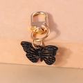 Détail d'un porte-clés papillon ajouré noir avec un fermoir mousqueton doré élégant - Papillon Creux (YZ952)