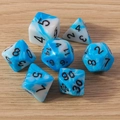 Close-up of blue and white marble resin polyhedral dice set on a light wood surface - 7-Pack Set / White and Blue