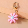 Detail eines rosa-blauen Gänseblümchen-Anhängers aus Harz mit goldenem Karabiner - Rosa