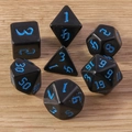 Set of seven black polyhedral dice with blue numbers on a rustic wooden table background - Black and Blue