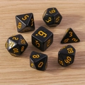 Detail of 7-piece polyhedral dice set featuring gold Gothic numbers on smooth black resin - Black and Yellow