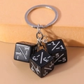 Close-up of three black dice keychain with silver -1/-1 counters for card games - Black