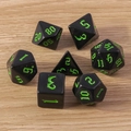 Detailed close-up of 7-piece polyhedral dice set on light wood background for TRPG gaming - Dark Green
