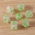Macro detail of iridescent translucent resin dice set with glowing green numbers on wood - 7-Pack Set / Transparent Green
