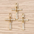 Close-up of golden infinity cross charms with pave rhinestones on a wood background - Infinity Symbol Cross / 10 Pieces Pack / Gold