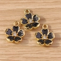 Three elegant black enamel flower charms with gold plating and zircon center on wood surface - 10 Pieces Pack / Black