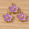 Detailed macro view of purple enamel flower pendants with gold plating and sparkling zircon - Purple