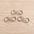 Macro shot of three silver infinity charm connectors for DIY jewelry making on wood background - 20 Pieces Set / Silver