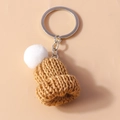 Détail d'un porte-clés bonnet en maille fait main en marron caramel avec pompon blanc - Marron