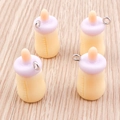 Detailed view of four resin baby bottle charms with purple caps and silver metal rings - 10 Pieces Pack / Yellow
