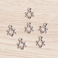 Vintage silver hollow star charms for jewelry making on light wood background - Hexagram Style (YJ499) / 100pcs Pack / Silver