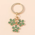 Porte-clés doré minimaliste avec trois pendentifs en forme de fleurs de cerisier vert - vert foncé