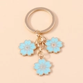 Eleganter Kirschblüten Schlüsselanhänger mit Goldring und hellblauen Emaille-Blumen - Blau