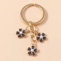Minimalistischer Schlüsselanhänger mit schwarzen Emaille-Blumen und weißen Perlen - Schwarz