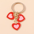 Porte-clés double cœur avec breloques en émail rouge et rose au fini doré chic - Rouge