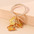 Golden butterfly keychain featuring orange gradient enamel pendants on a minimalist ring - Orange
