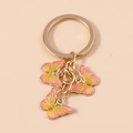 Sweet butterfly keychain featuring pink and yellow gradient enamel charms in gold finish - Pink